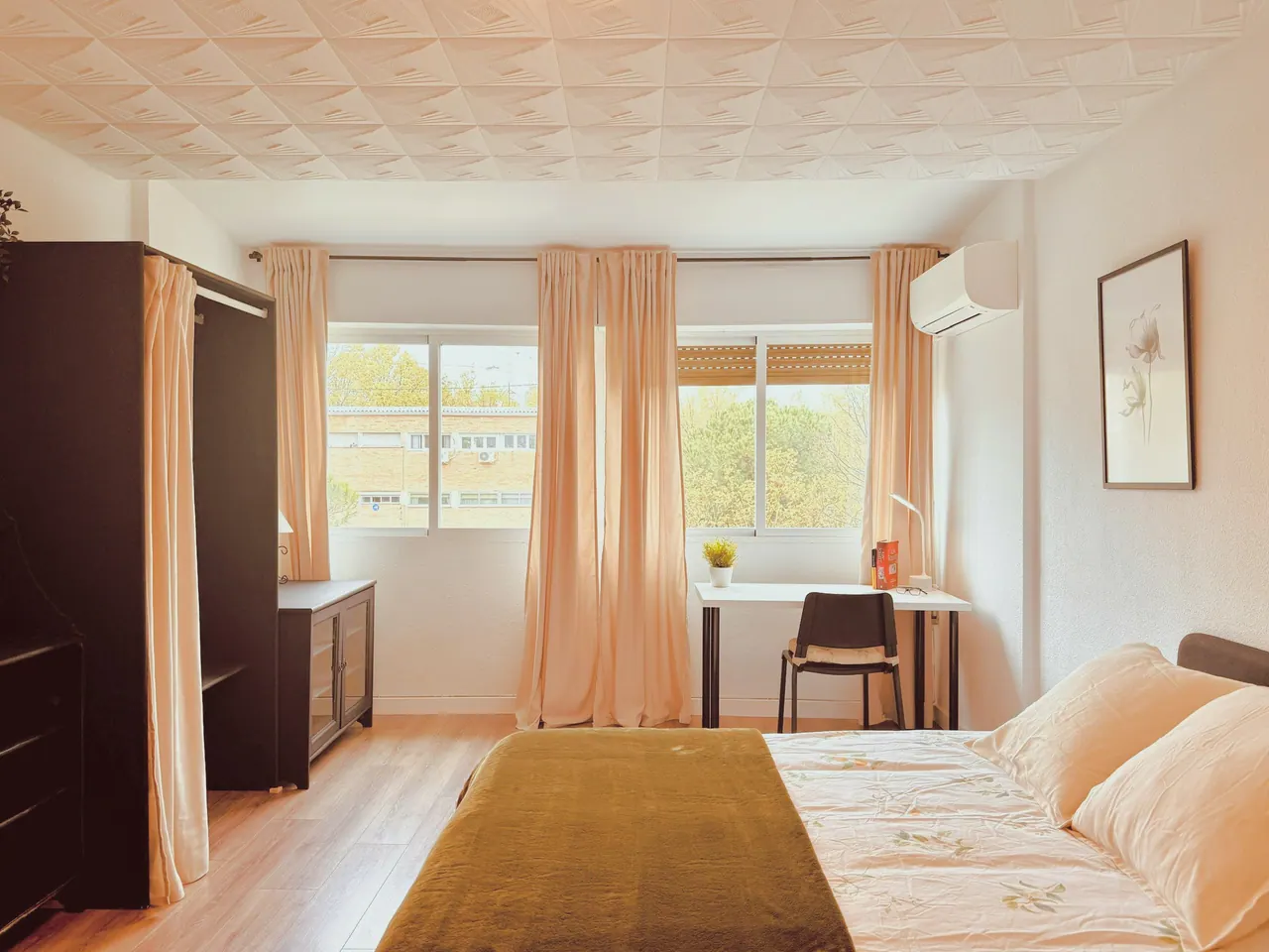 Habitación con cama de matrimonio, escritorio bajo dos ventanas, armario y aire acondicionado (foto 6 de 9)