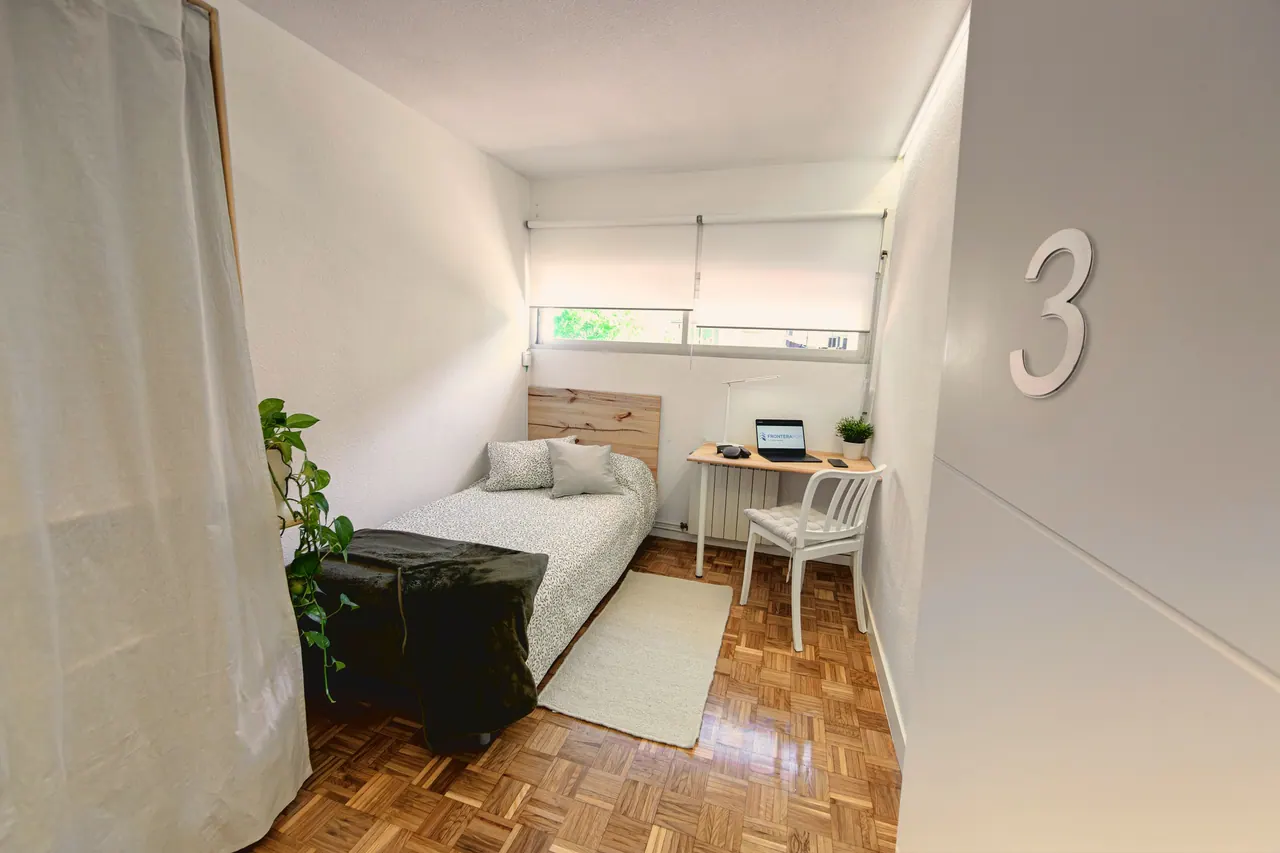 Habitación con cama individual, escritorio con portátil y suelo de parqué (foto 7 de 7)