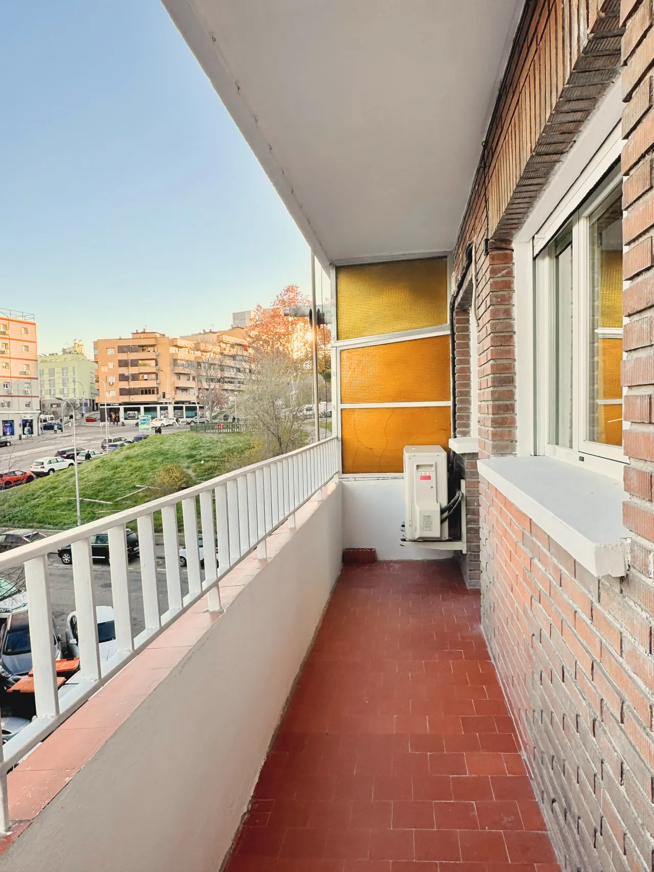 Terraza alargada con barandilla blanca y suelo de baldosa roja (foto 3 de 7)