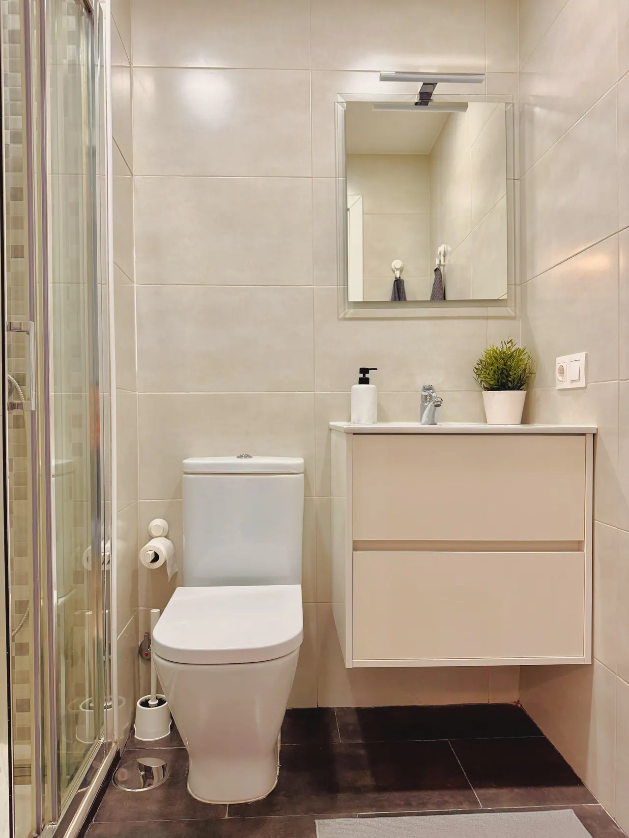 Baño con mueble de lavabo suspendido, espejo, inodoro y ducha (foto 4 de 7)
