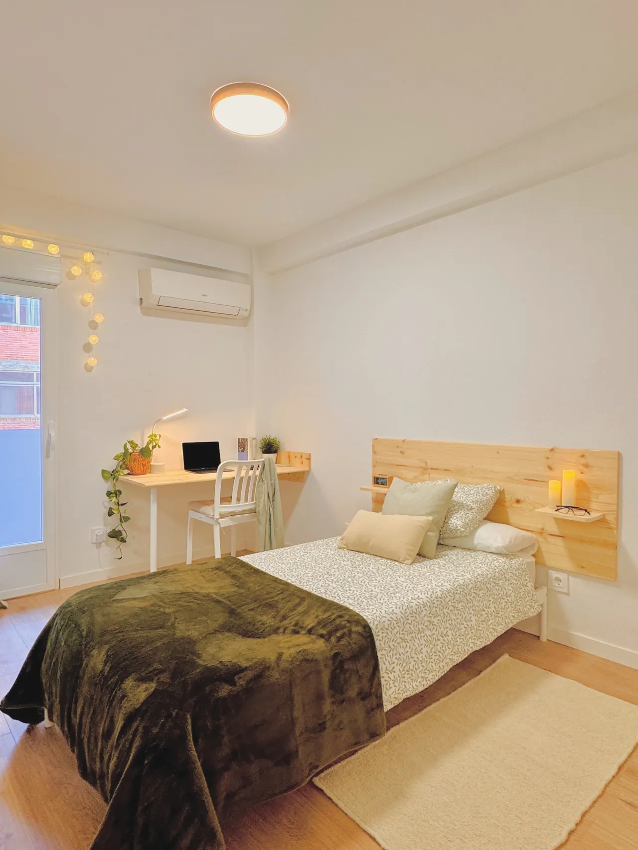 Habitación con cama individual, cabecero de madera, escritorio y guirnalda de luces (foto 7 de 7)