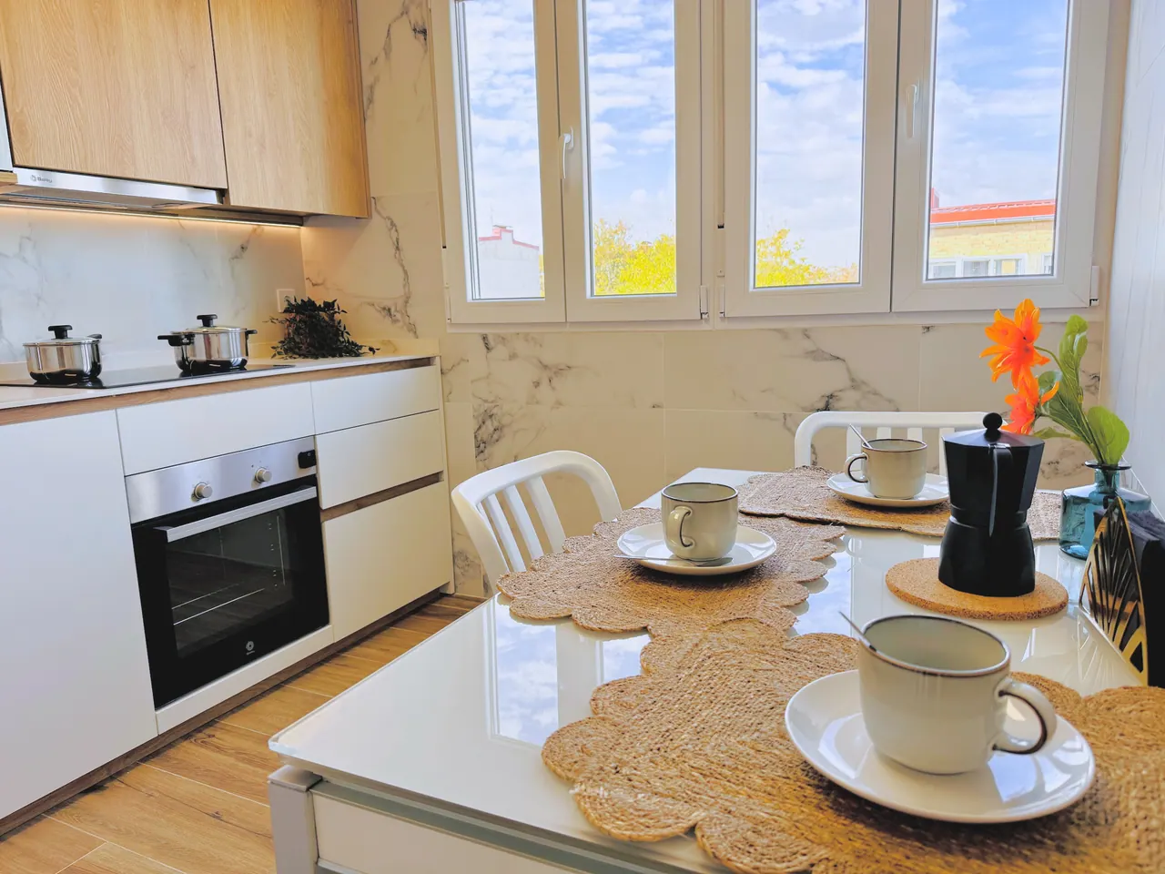 Mesa de desayuno con tazas y cafetera junto a la ventana de la cocina (foto 2 de 8)