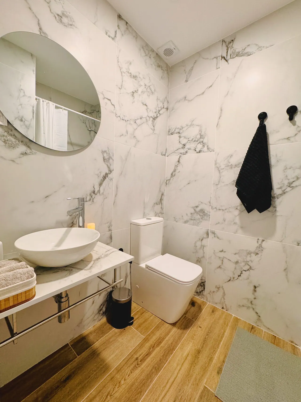 Segundo baño con lavabo sobre encimera, espejo redondo e inodoro (foto 4 de 8)