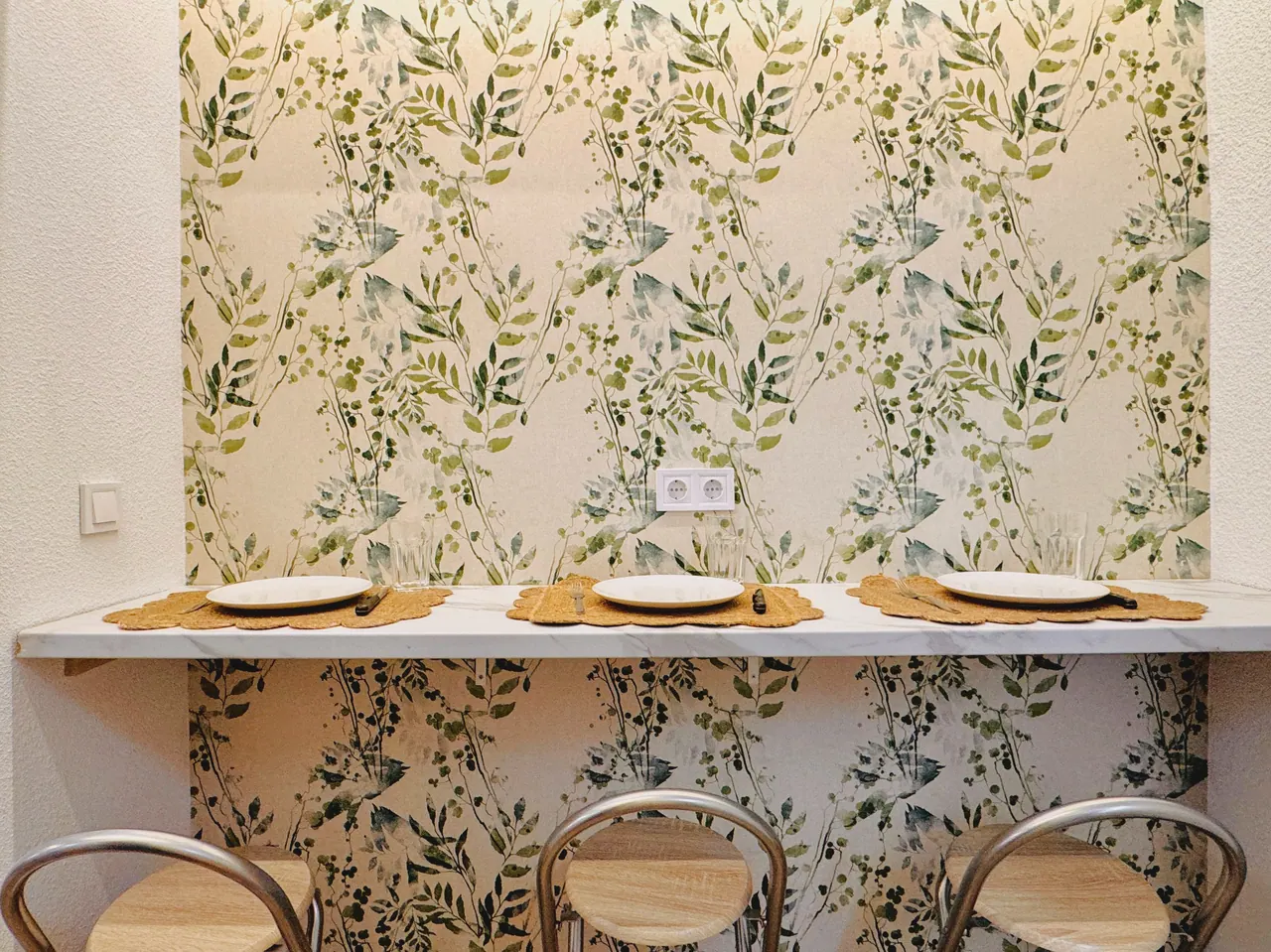 Barra de comedor con tres taburetes y papel pintado de hojas verdes (foto 2 de 8)