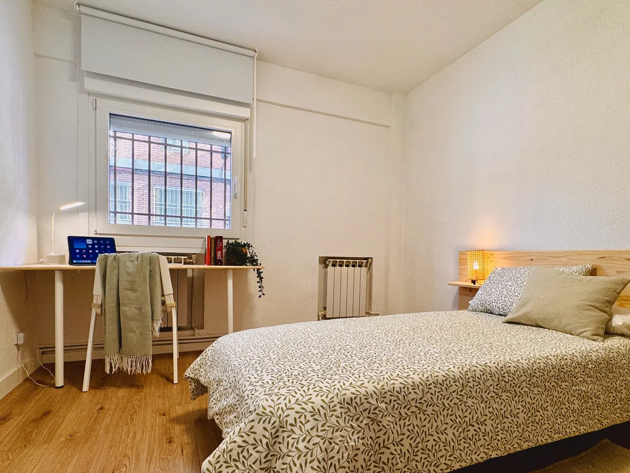 Habitación con cama de matrimonio, escritorio bajo la ventana y radiador (foto 5 de 8)