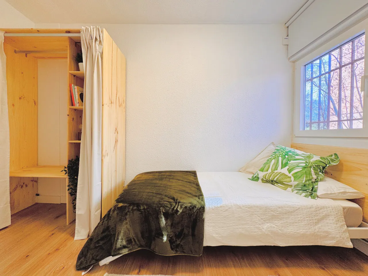 Habitación con cama, armario de madera y ventana con reja (foto 8 de 8)